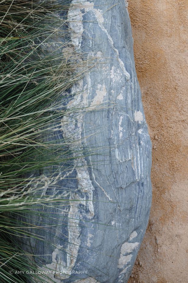 Schist boulders from a local quarry were selected to border the sandpits and garden areas.