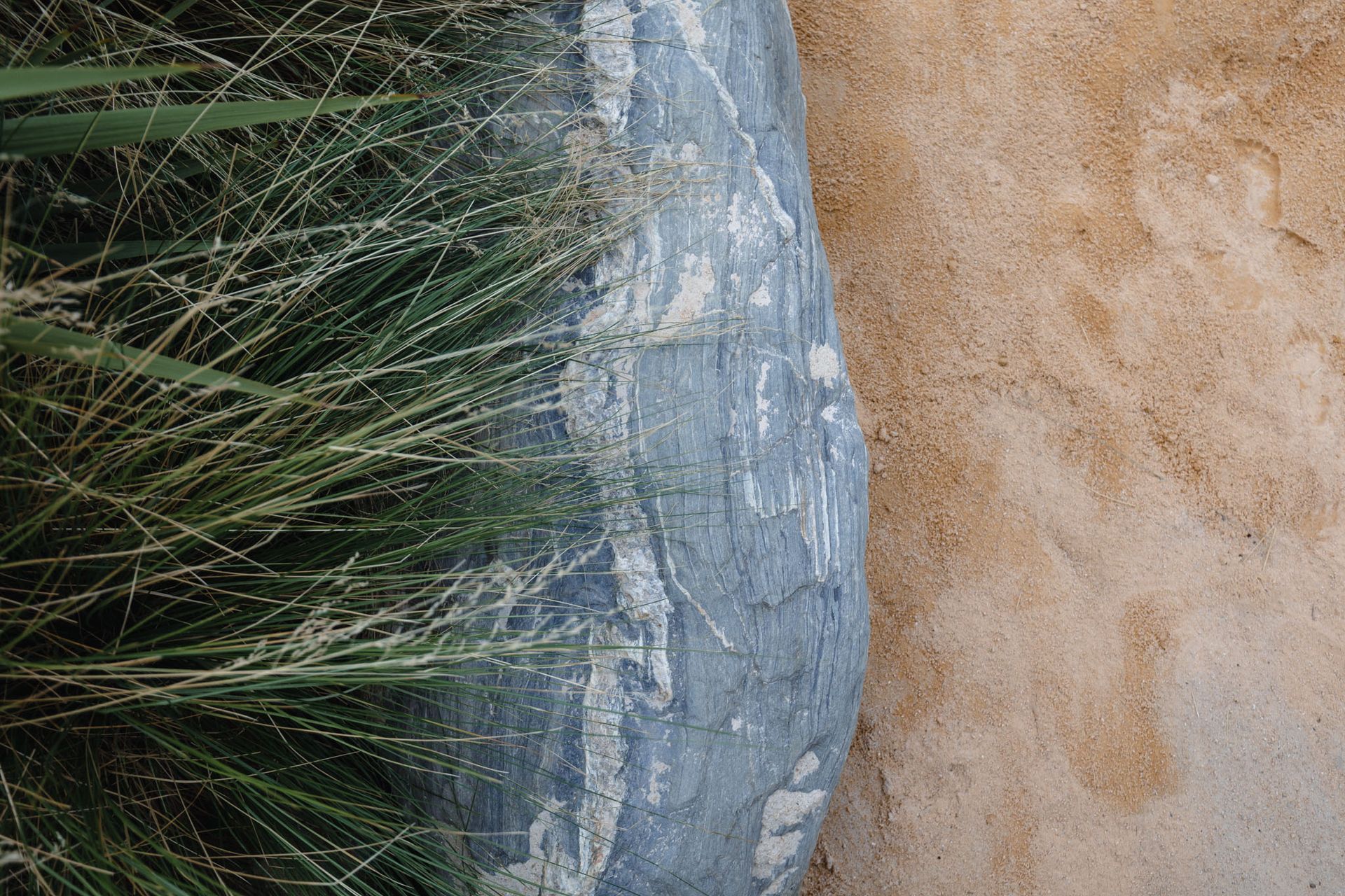 Schist boulders from a local quarry were selected to border the sandpits and garden areas.
