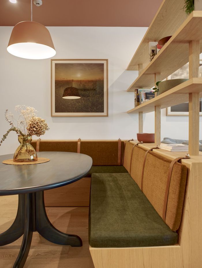 A tiered shelf with integrated custom-made bench seating separates the dining and lounge area | Photography by Ben Rowsell