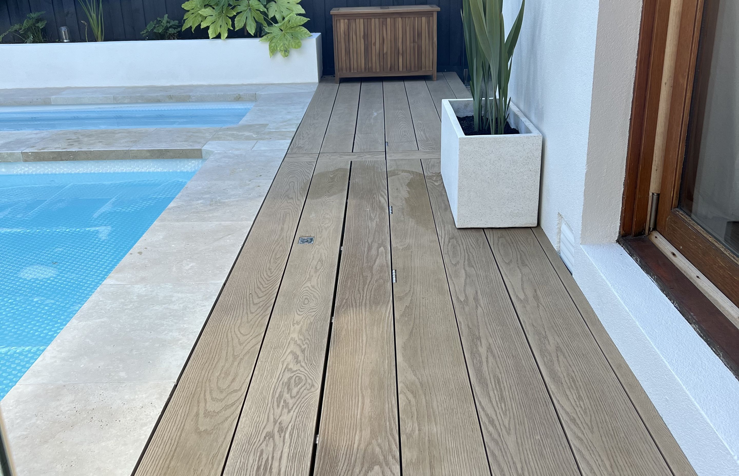 This timber decking pool cover is so seamless, it's practically invisible.