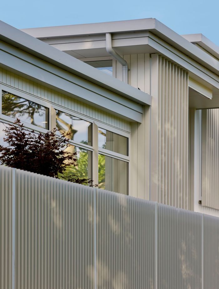 White-painted timber cladding reflects the coastal New Zealand architectural identity.