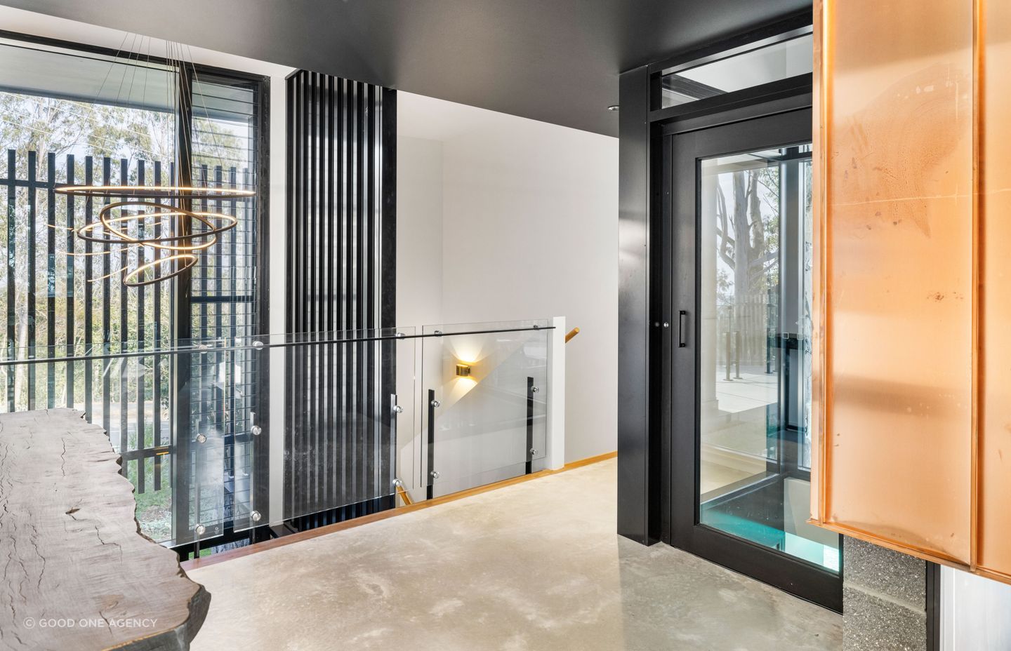 The glass lift takes in the view of the pool as it ascends.