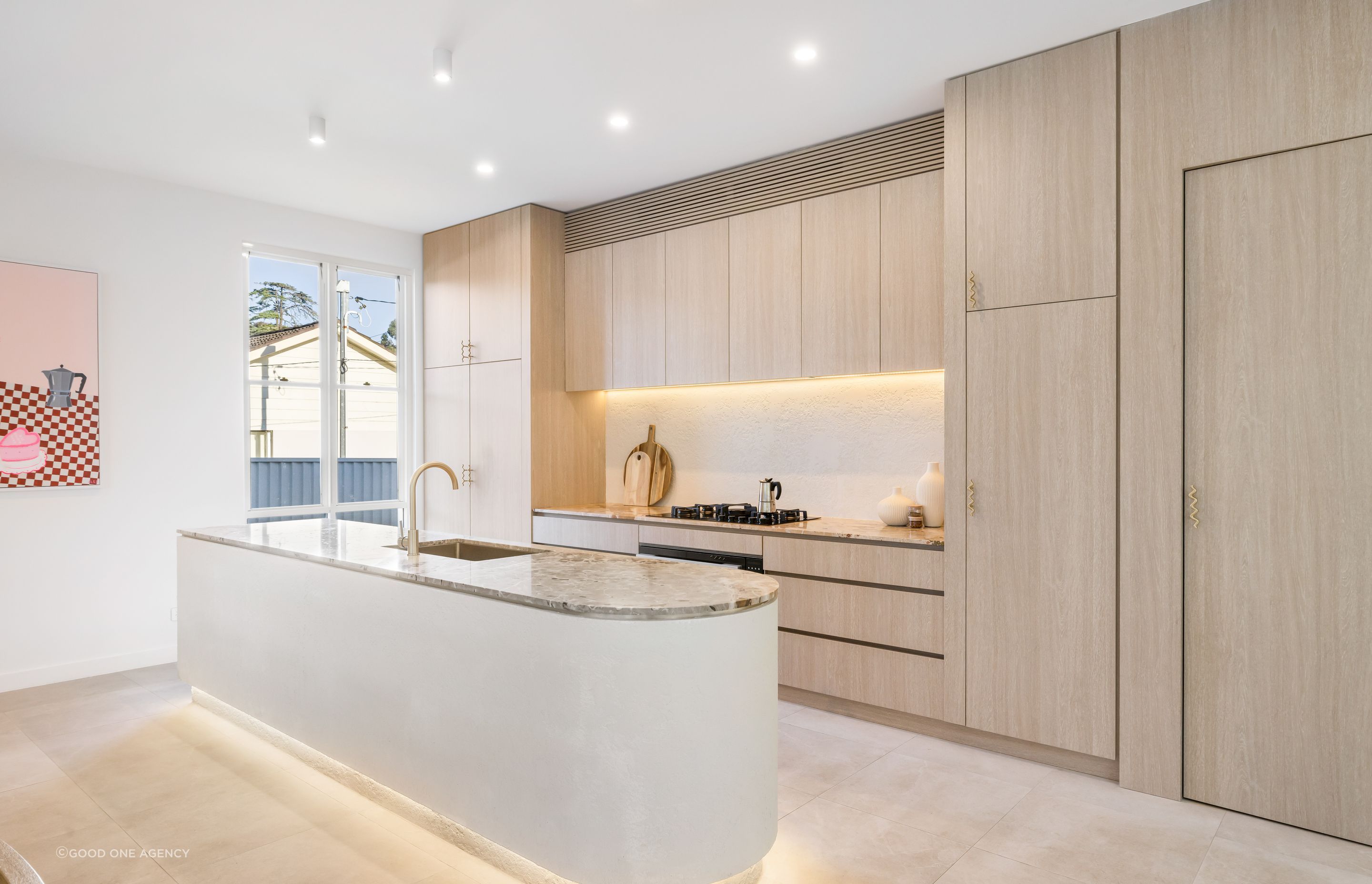 The kitchen features a pale palette and Botticelli marble benchtops.