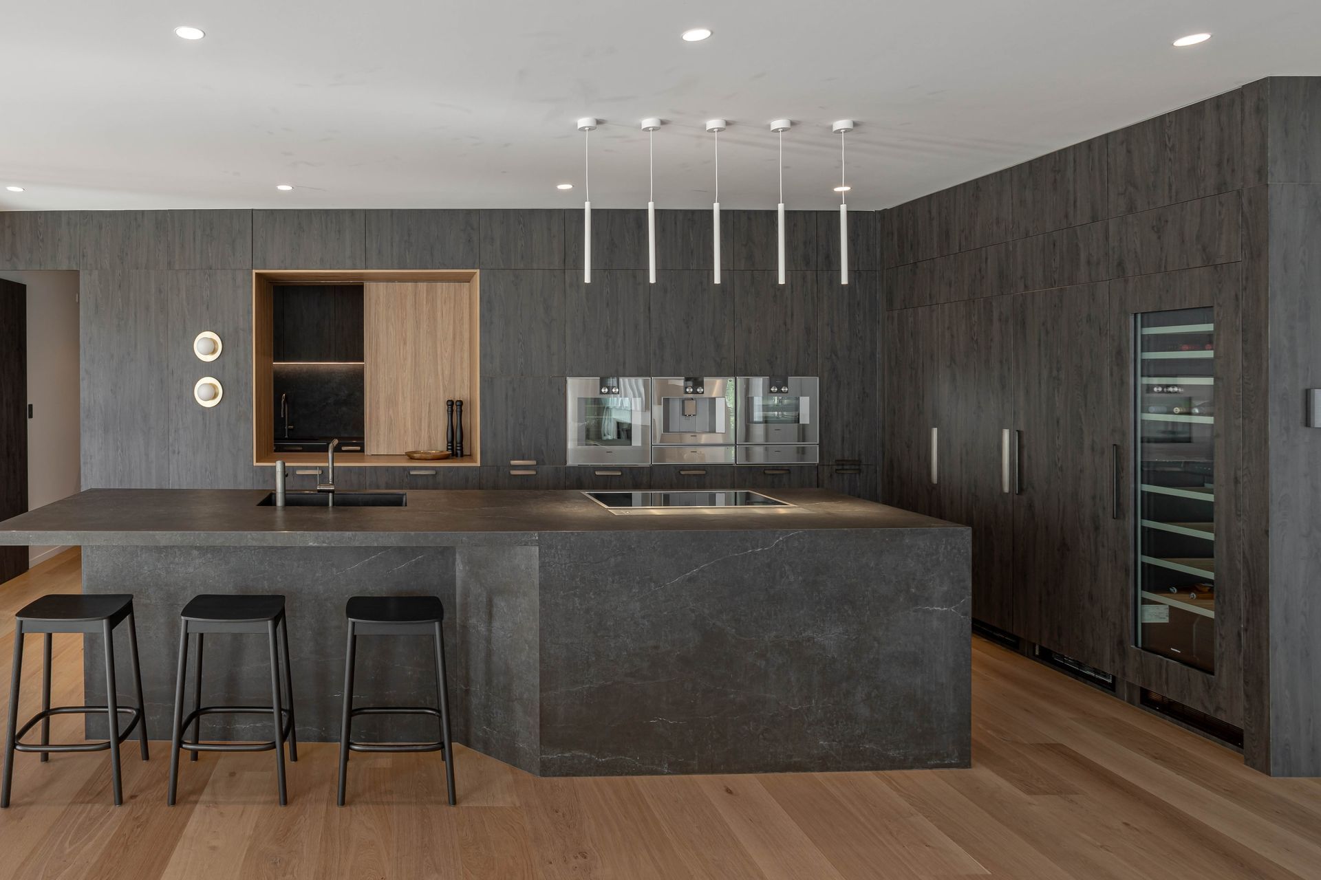 Dekton Laos was used on the kitchen island and the waterfall edges of the back bar, as well as on the worktop and pantry splashback.