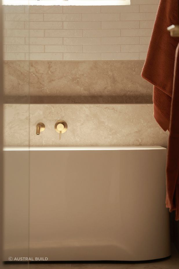Every detail has been considered, with brass fixtures and a niche for easy reach while in the bathtub.