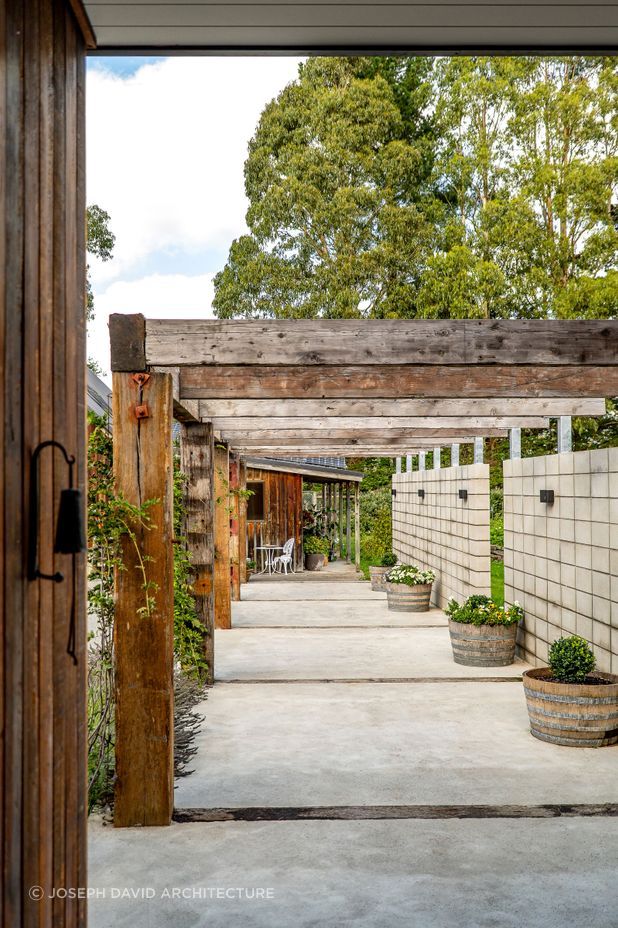 The solid timber pergola connects the house and barn.