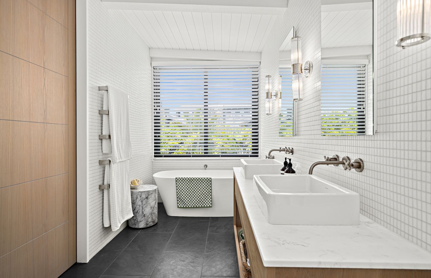 A Carrara marble benchtop pairs with white Vixel glass mosaic tiles from Artedomus in the main bathroom.