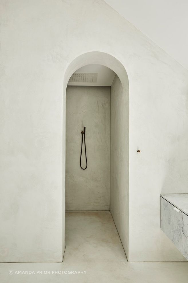 An archway entry adds drama to the master walk-in shower.
