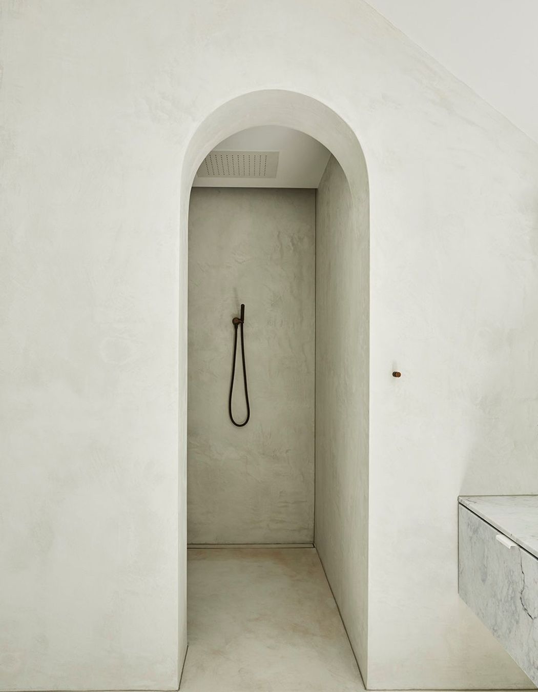 An archway entry adds drama to the master walk-in shower.