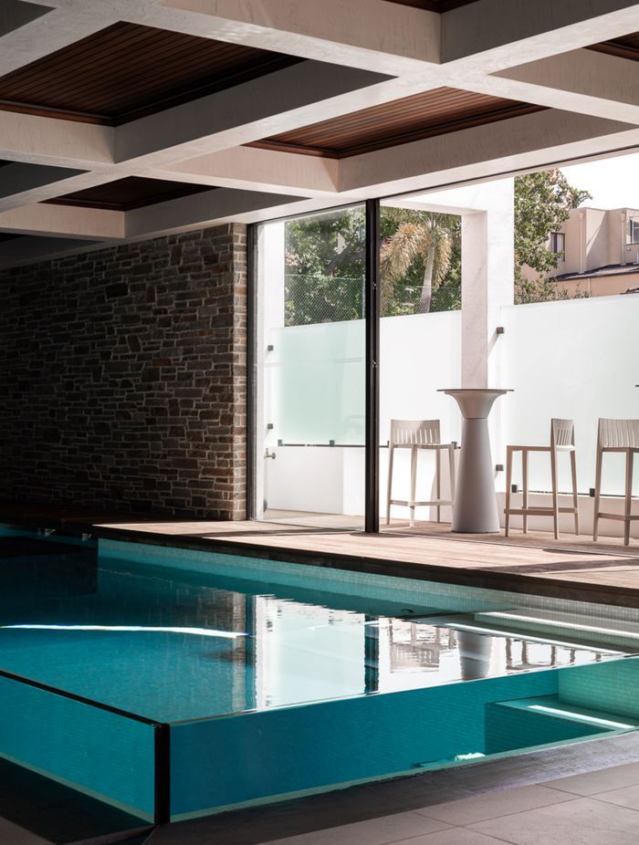 The 63mm glass walls of the pool protrude from the ground, creating the surreal effect of a clear container of water.