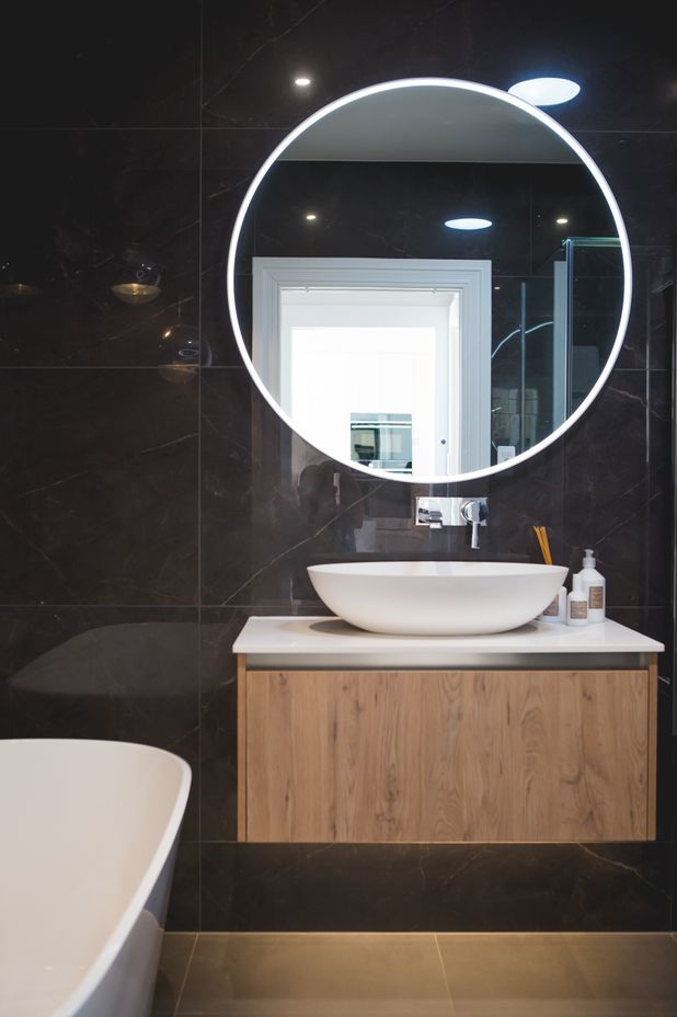 Dark-coloured tiles from Tile Warehouse create a modern aesthetic in the bathrooms.