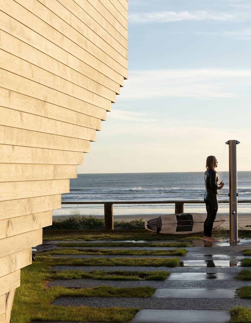 A surfer enjoys an outdoor shower at the front of the building. Ken says the beautiful new building hasn't suffered any tagging, and he often sees members of the community gather outside for morning coffee to interact and enjoy the facility.