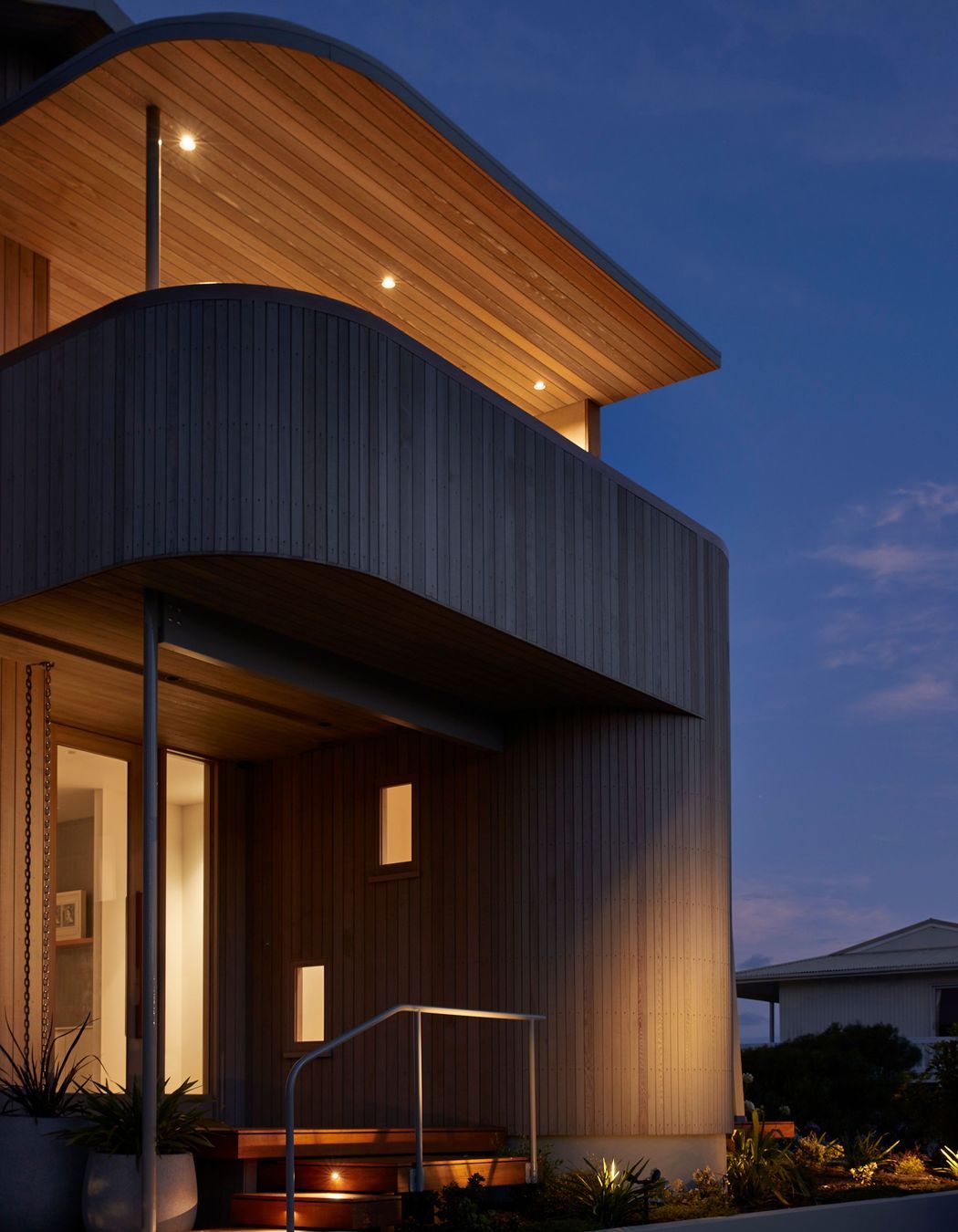 The cedar-clad and curved entry to Tent House. | Photographer: Jackie Meiring