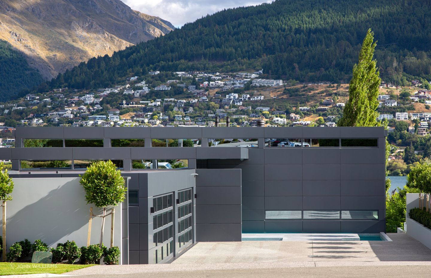 Arriving from the street or lake, a sense of intrigue is immediate. Behind the boundary walls, layers of rectangular, modernist shapes are revealed.