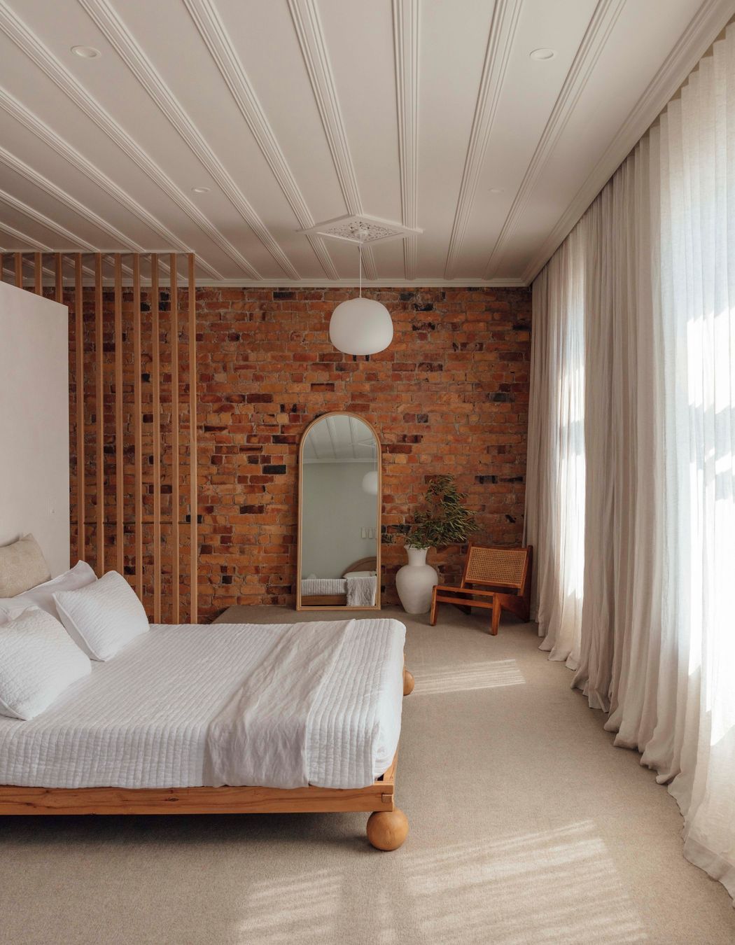 In the bedroom, the original kauri ceiling and brickwork have been restored.