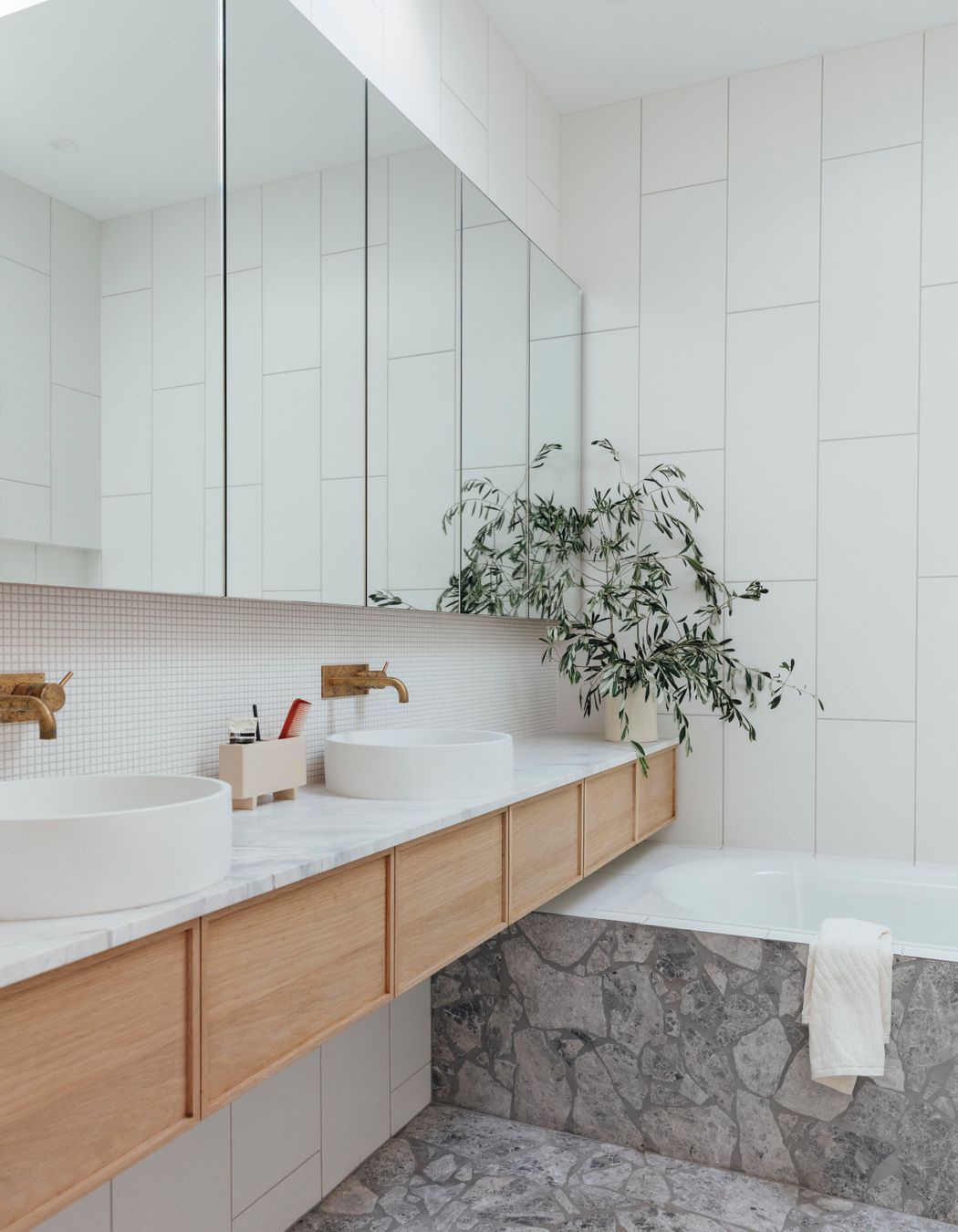 An ensuite uses a light, fresh material palette.
