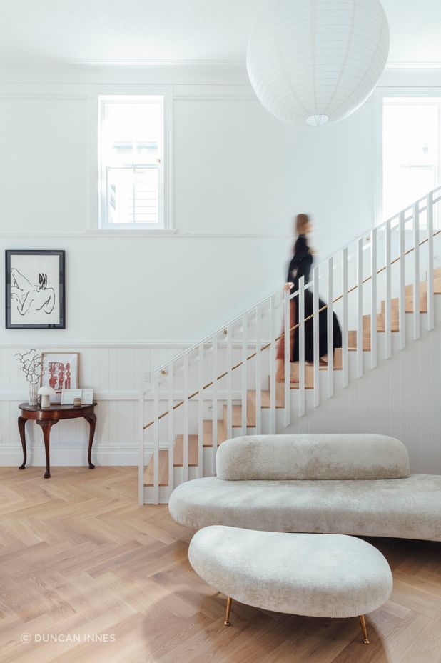 A timber screen marks the stairs leading up to the primary bedroom in the northwestern corner of the main hall.