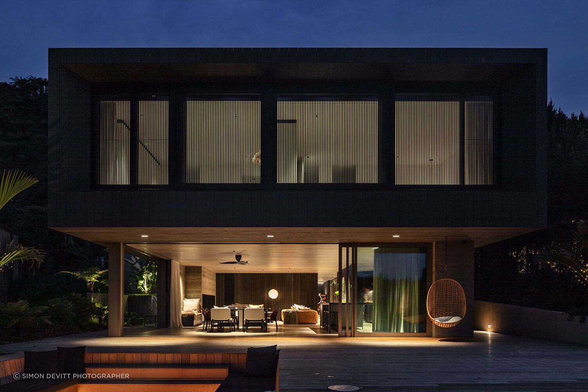 Sam and Fiona Fillmore’s lakehouse on the edge of Lake Rotoiti was designed by Evelyn McNamara of Evelyn McNamara Architecture. The ground-level glass doors open completely to welcome and provide a connection to Sam’s childhood bach next door.