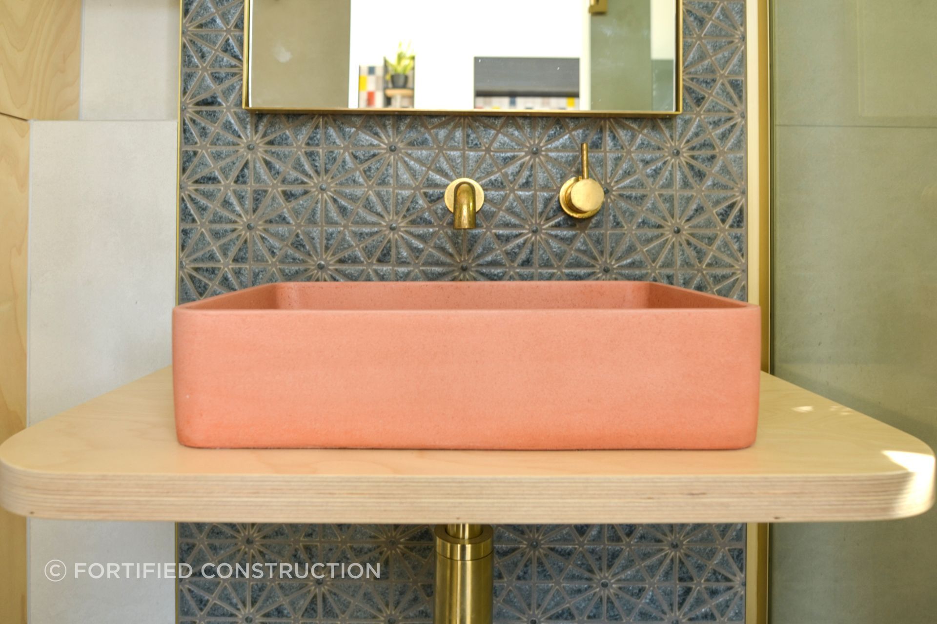 The salmon pink vessel sink showcases the client's affinity for colour.