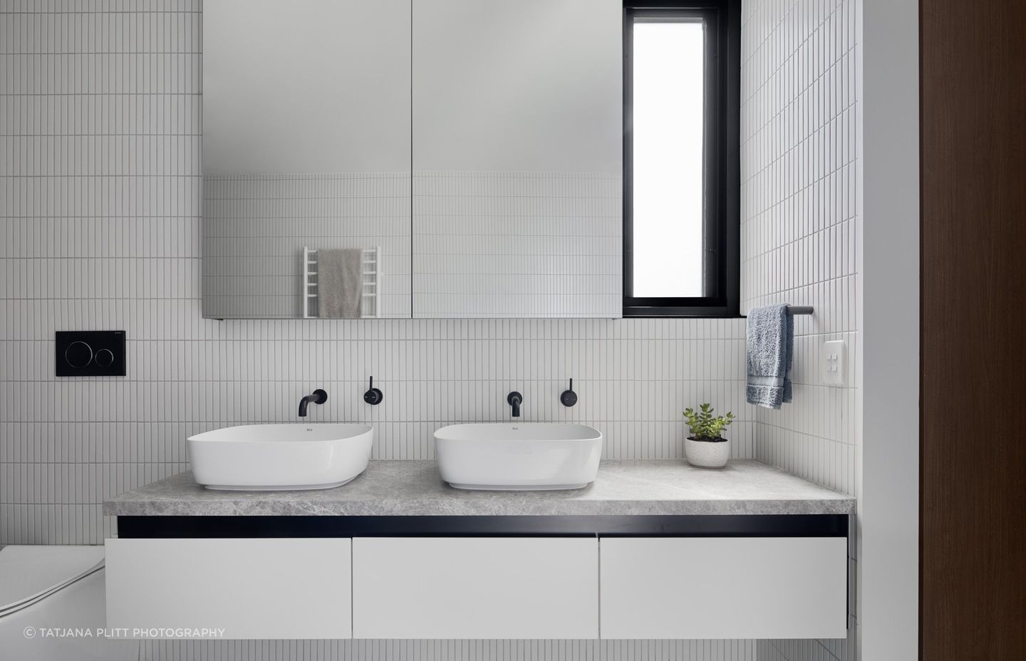 Similar to downstairs, the bathroom has a monochromatic scheme of black and white.