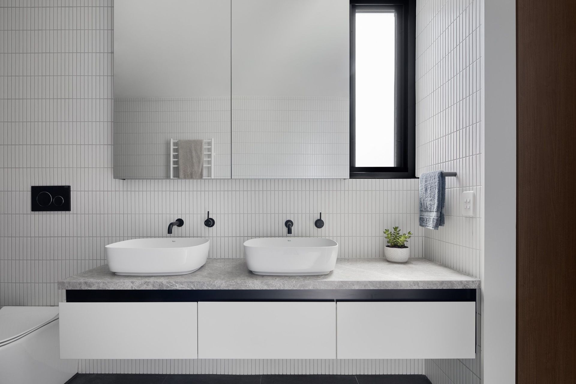 Similar to downstairs, the bathroom has a monochromatic scheme of black and white.