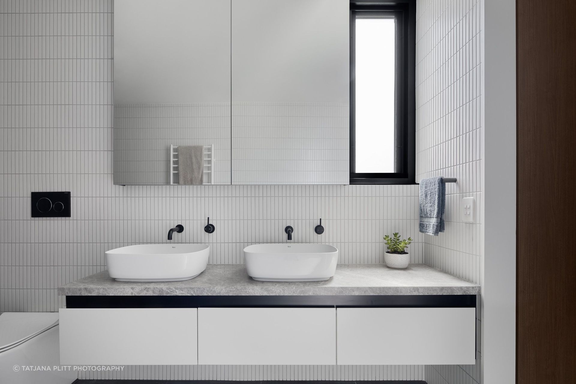 Similar to downstairs, the bathroom has a monochromatic scheme of black and white.