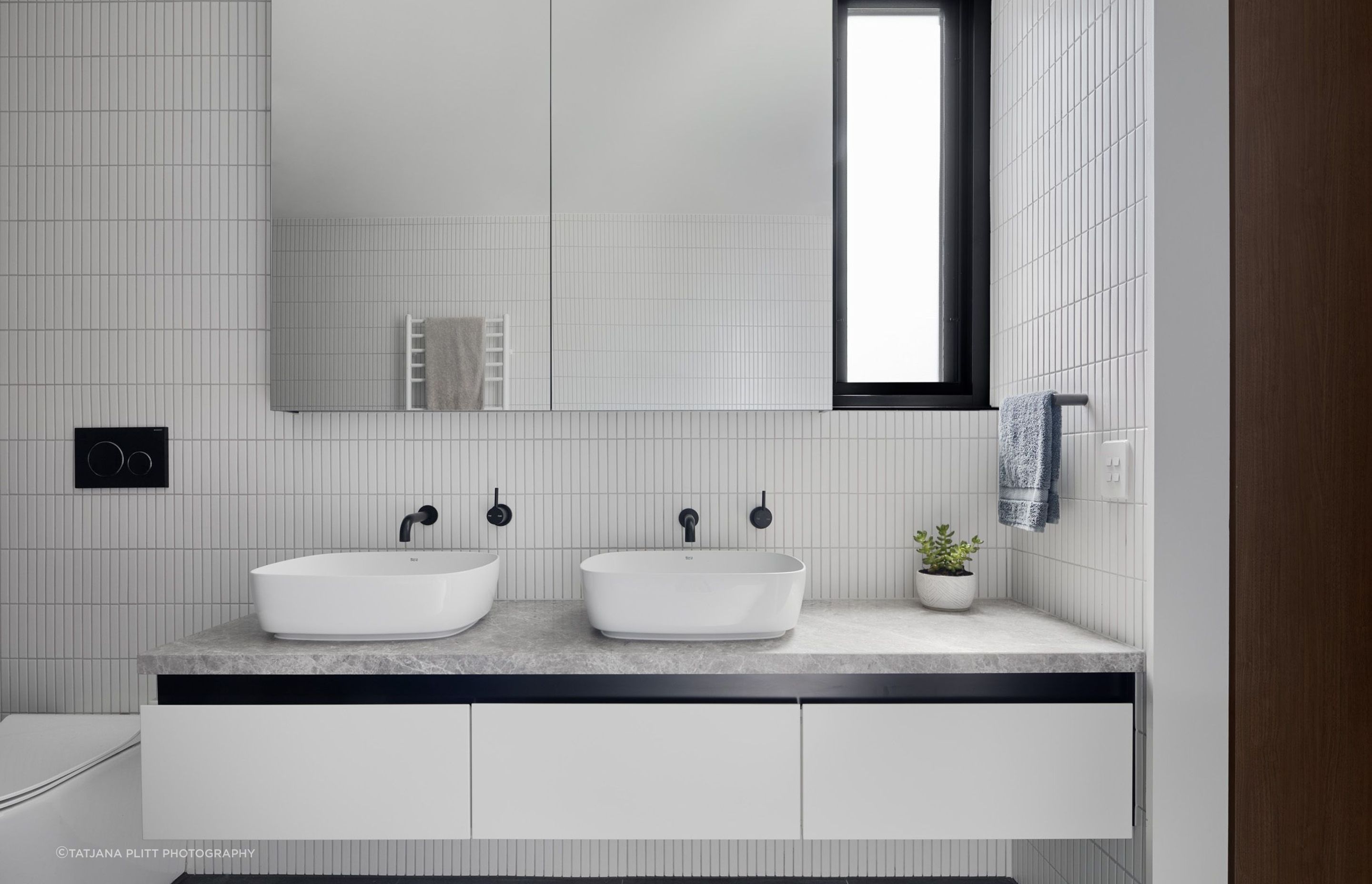Similar to downstairs,  the bathroom has a monochromatic scheme of black and white.