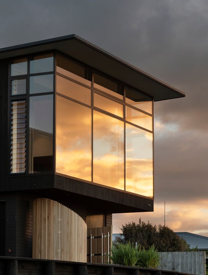 The curved structure is made of Accoya slats and contains an outdoor shower for when the family comes up from the beach.