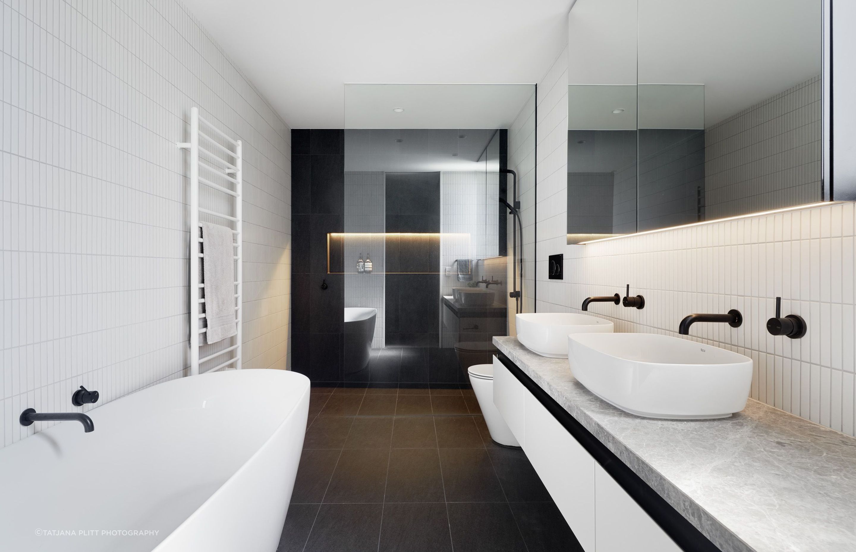 White finger tiles and black tapware feature in the master ensuite.