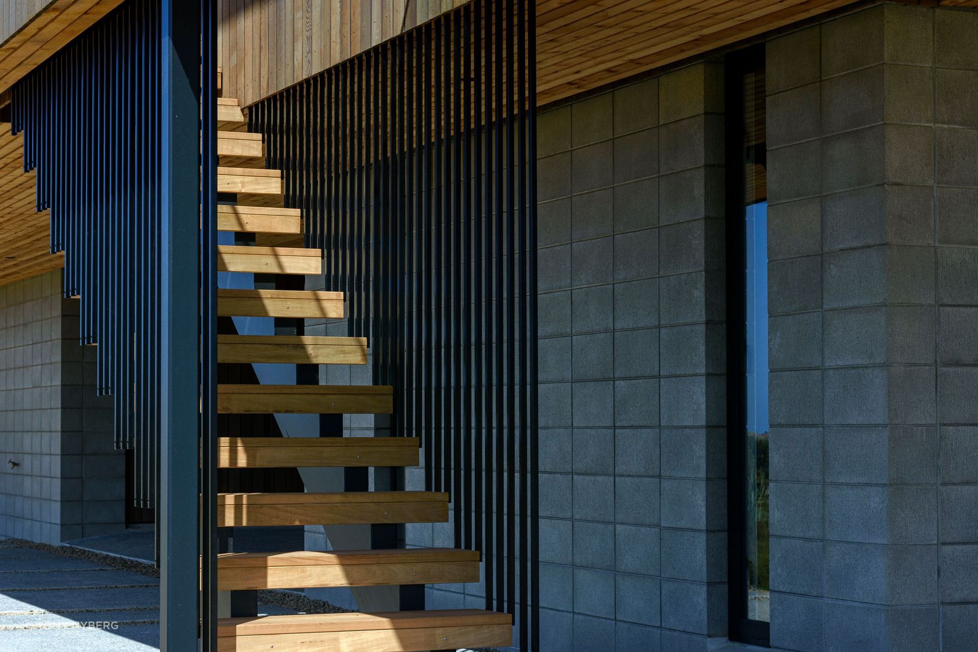 A block base combines with black aluminium and cedar for the home's exterior.