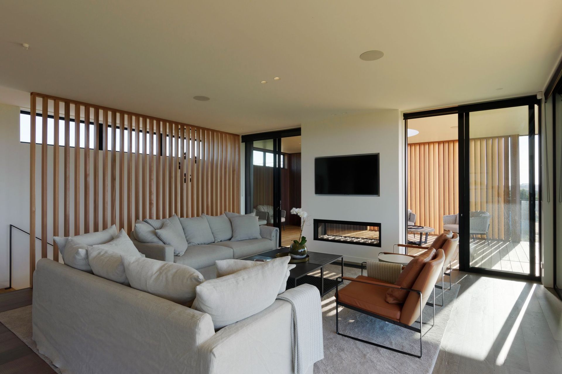 A double-sided fireplace sits at the junction between the indoor and outdoor living areas.