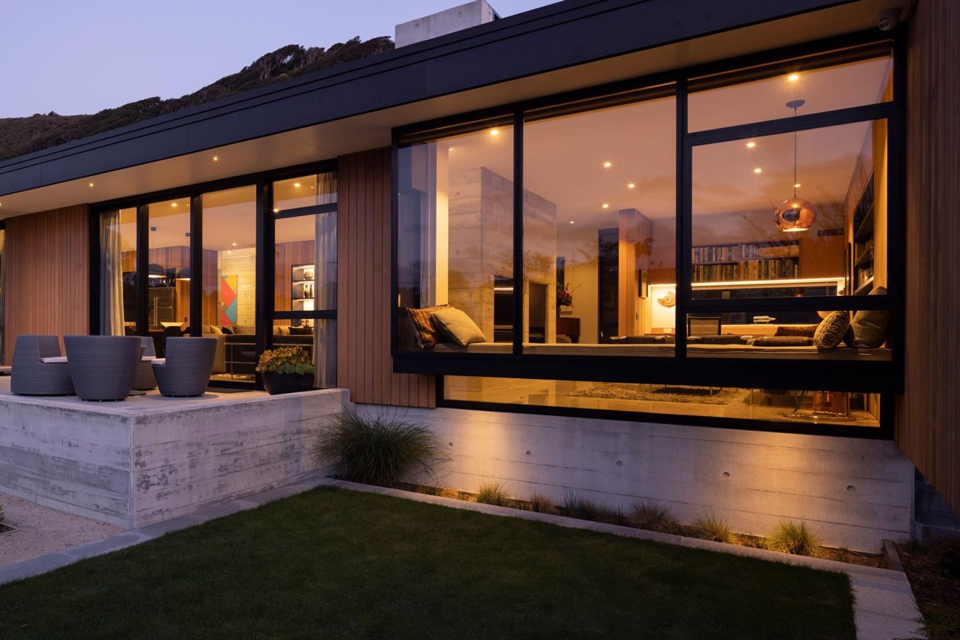 A floating wing wall on the right screens the terrace from southerly winds and provides a sense of enclosure. The cosy window seat in the den area looks over the garden.