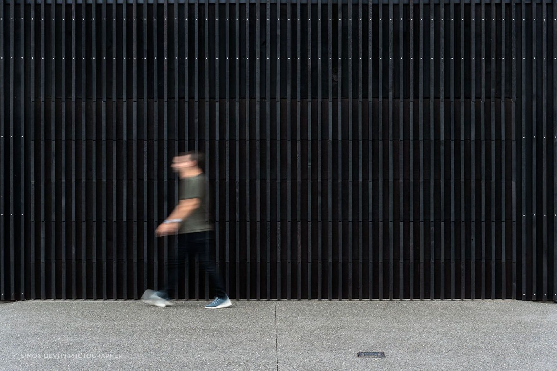 Black-stained vertical timber fins extend upwards, protecting the home from prying eyes.