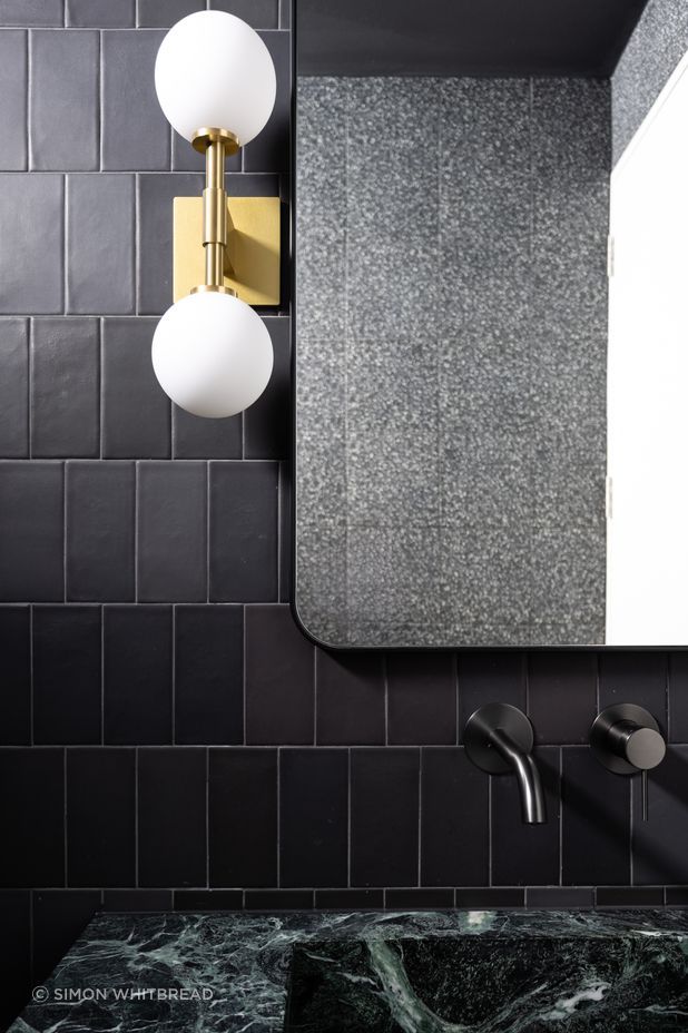 The brass wall light from Allied Maker is a luxurious touch to the bathroom.