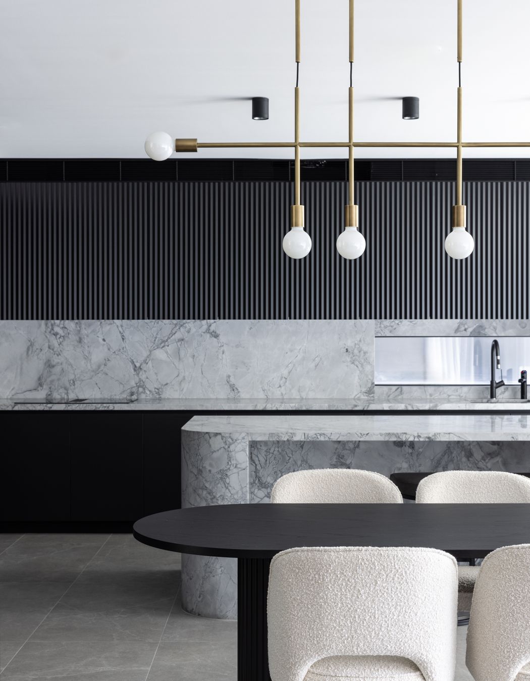 The brass pendant ties in with brass accents found throughout the home – even the feet of the dining chairs.