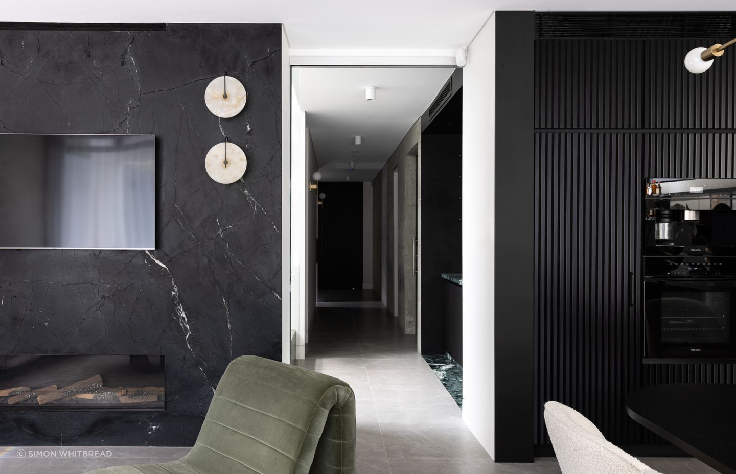 The moody interior scheme is really experienced in the kitchen, dining and living area with its black cabinetry and marble.