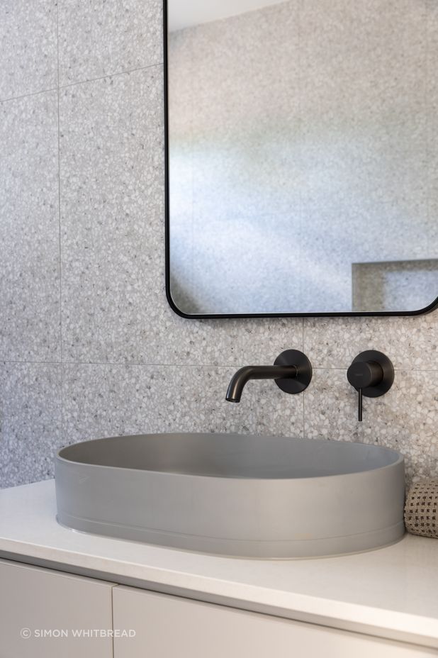Terrazo, marble and concrete come together in the main bathroom.