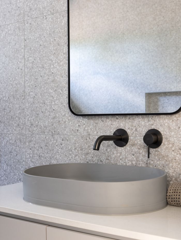 Terrazo, marble and concrete come together in the main bathroom.