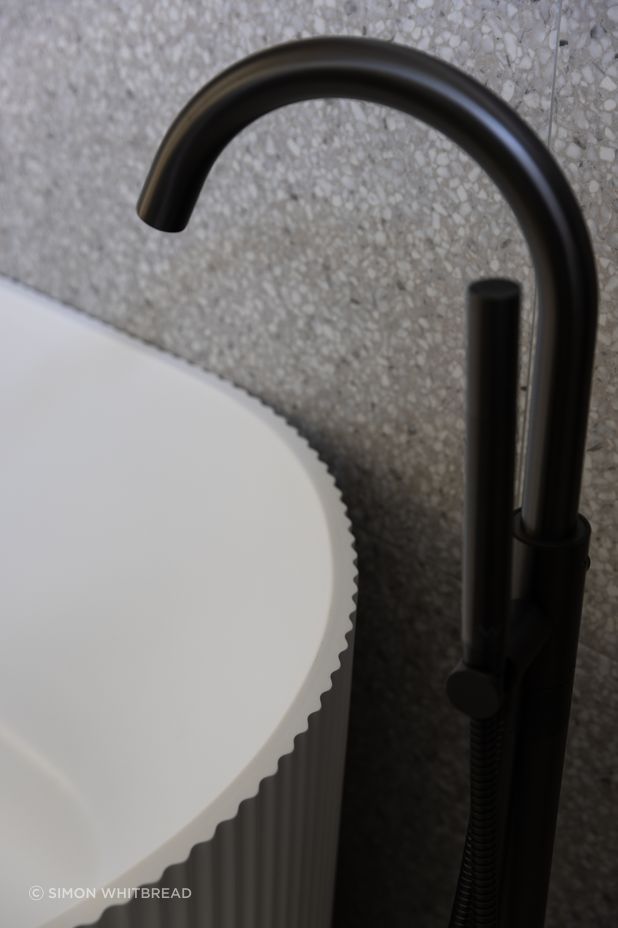 No attention to detail has been spared with the bathtub in the main bathroom a nod to the fluted pattern of the kitchen cabinetry.