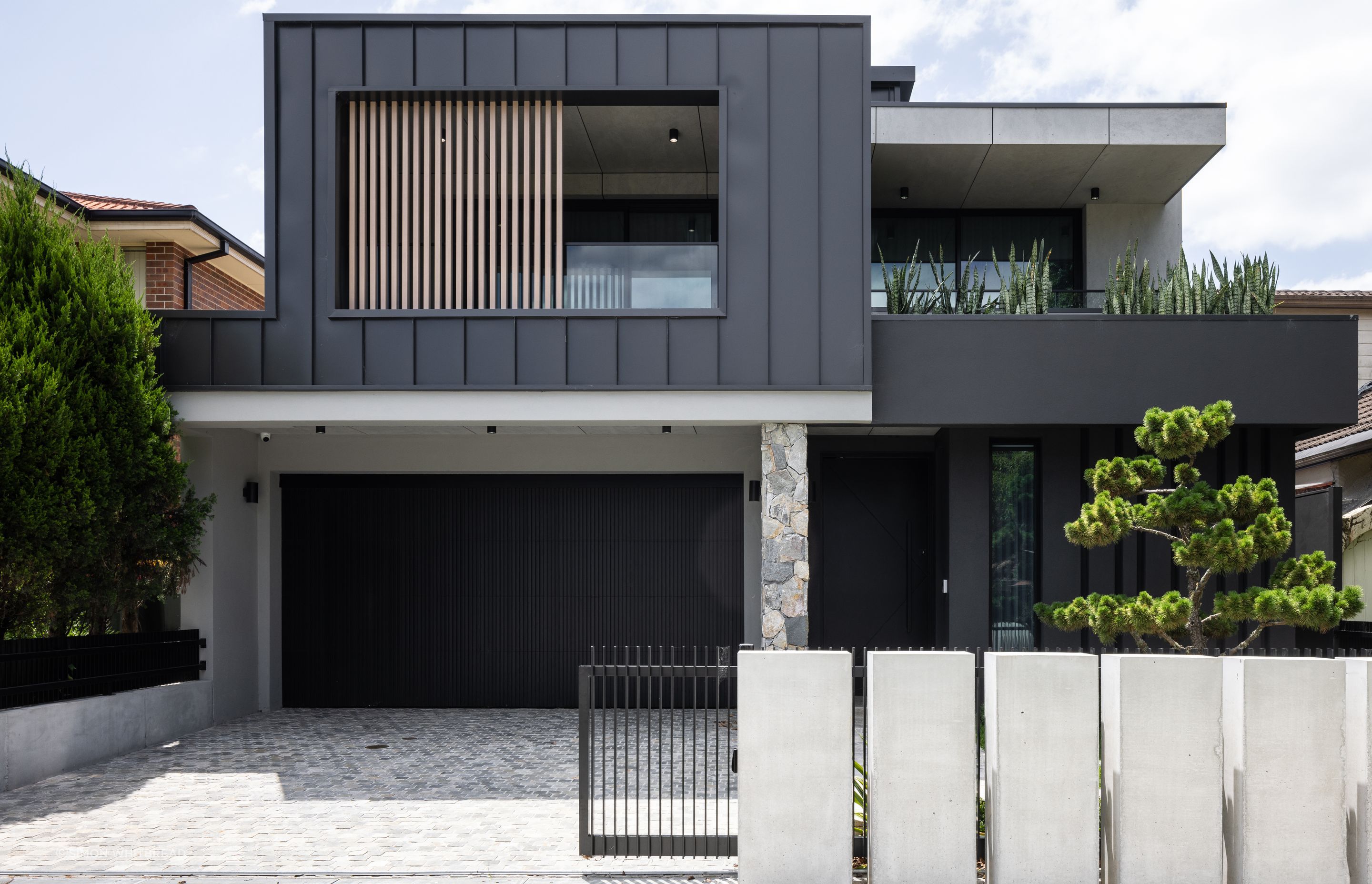 The exterior is a prelude to the interior: concrete, natural stones and dark surfaces.