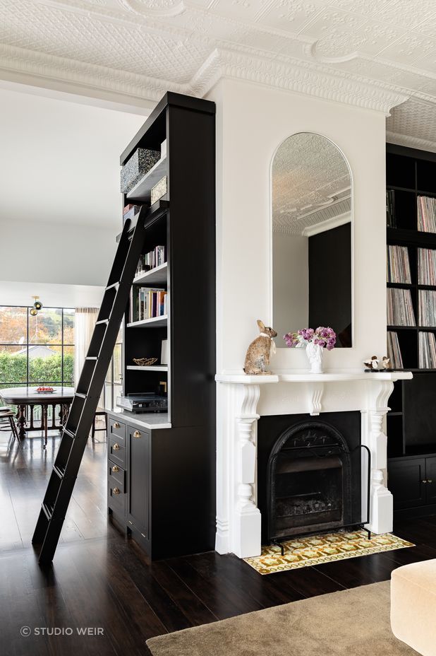 The bespoke timber library with ladder access holds a categorised 1,000+ strong vinyl collection that has been almost 20 years in the making. There is also a laundry chute hidden in cabinetry at the base of the bookshelf.