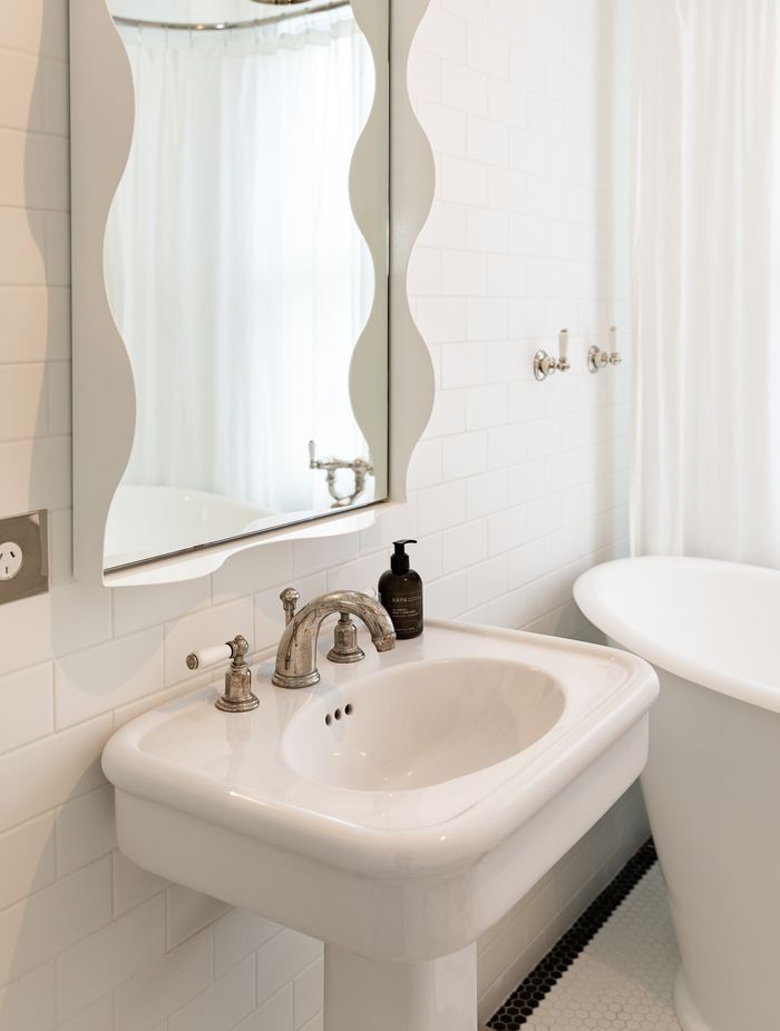 A wavy mirror brings a sense of fun to the children's bathroom. The traditional-style tapware is Perrin &amp; Rowe.