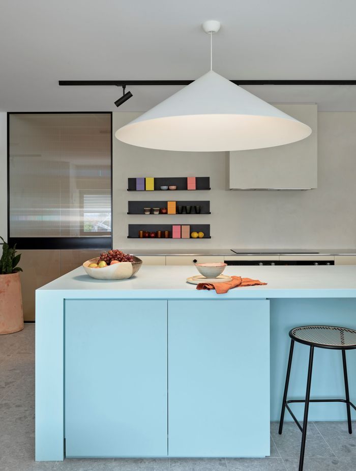 The kitchen combines strong shapes with soft, pastel colours to create a homely yet robust space for the staff to cook and eat.