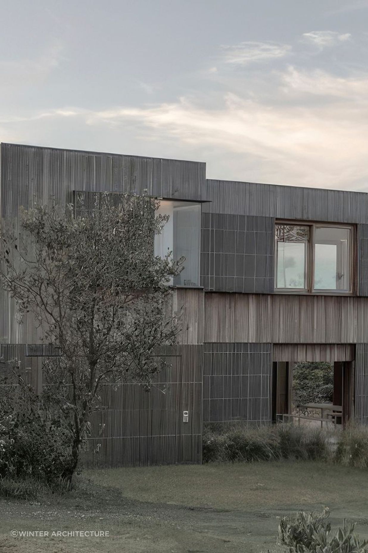 The weatherboard cladding blends with the surrounding grasslands.