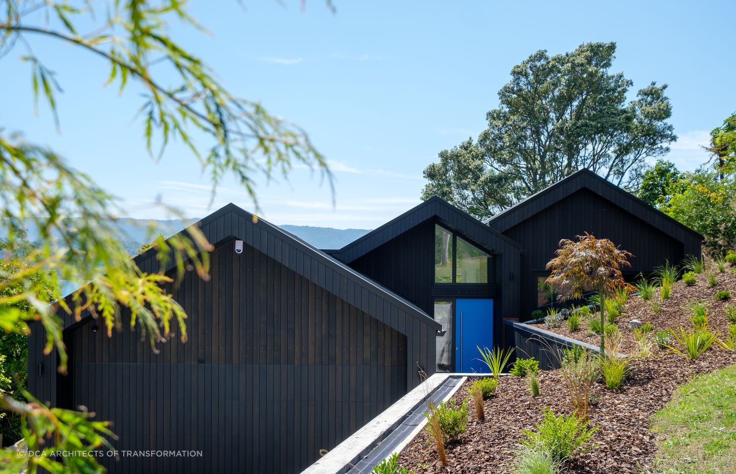 The exterior of Black Gables House, designed to passive house principles, with the tranquil Lake Tarawera in the distance.