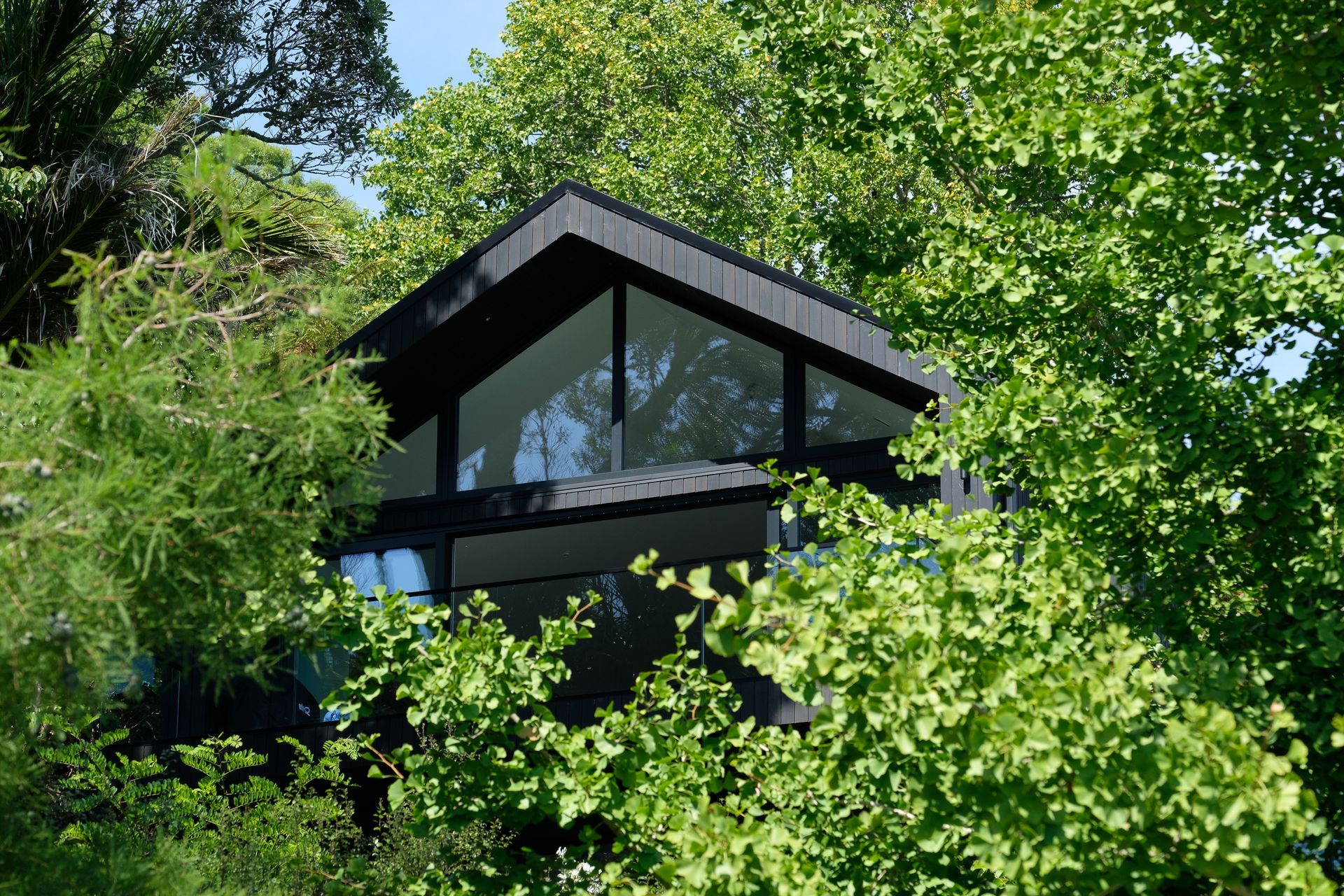 The gabled roof profile peaks out among lush surroundings.