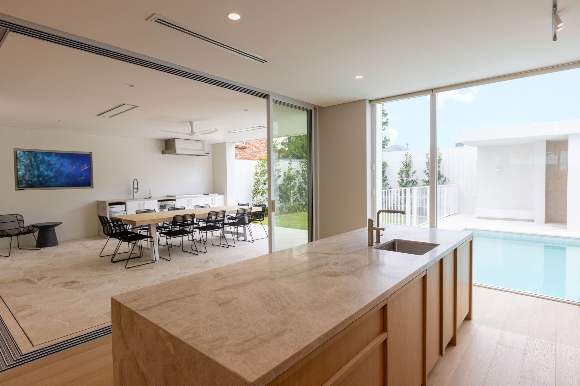 Floor-to-ceiling glazing seamlessly connects the indoor and outdoor spaces.