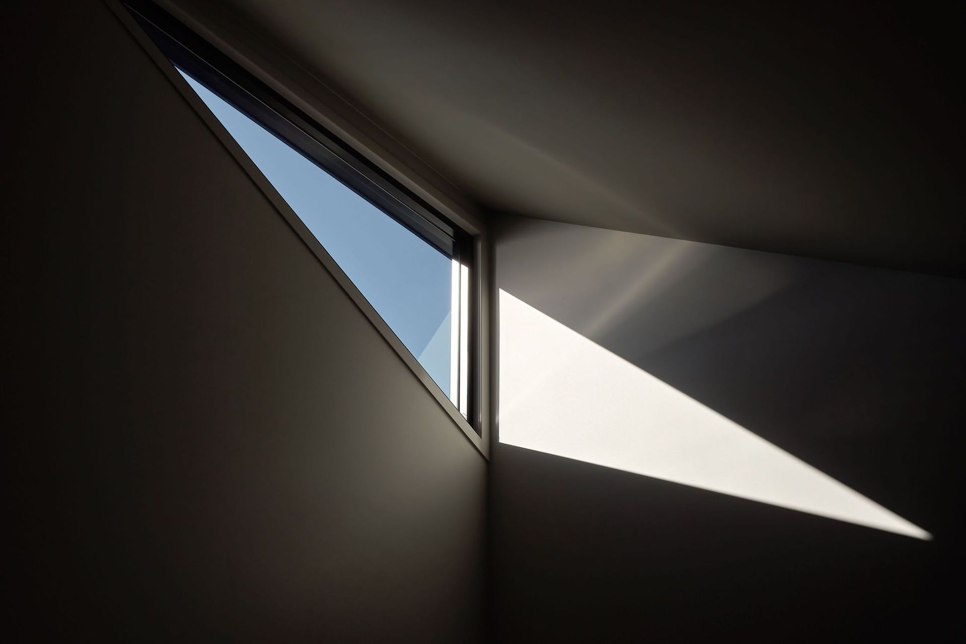 Strategically positioned geometric windows and the layering of facades and textures invites a myriad of light and shadows through the home.