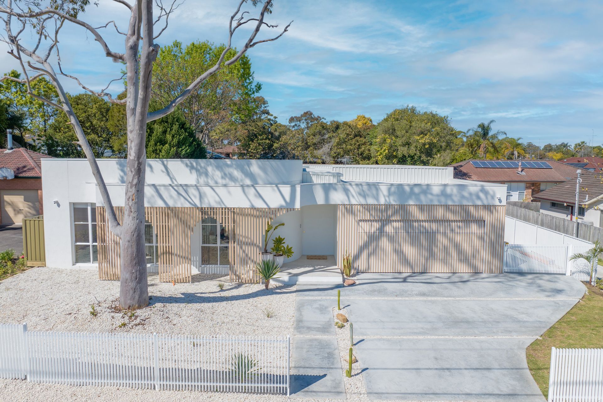 The pale exterior palette reflects the Mediterranean aesthetic.