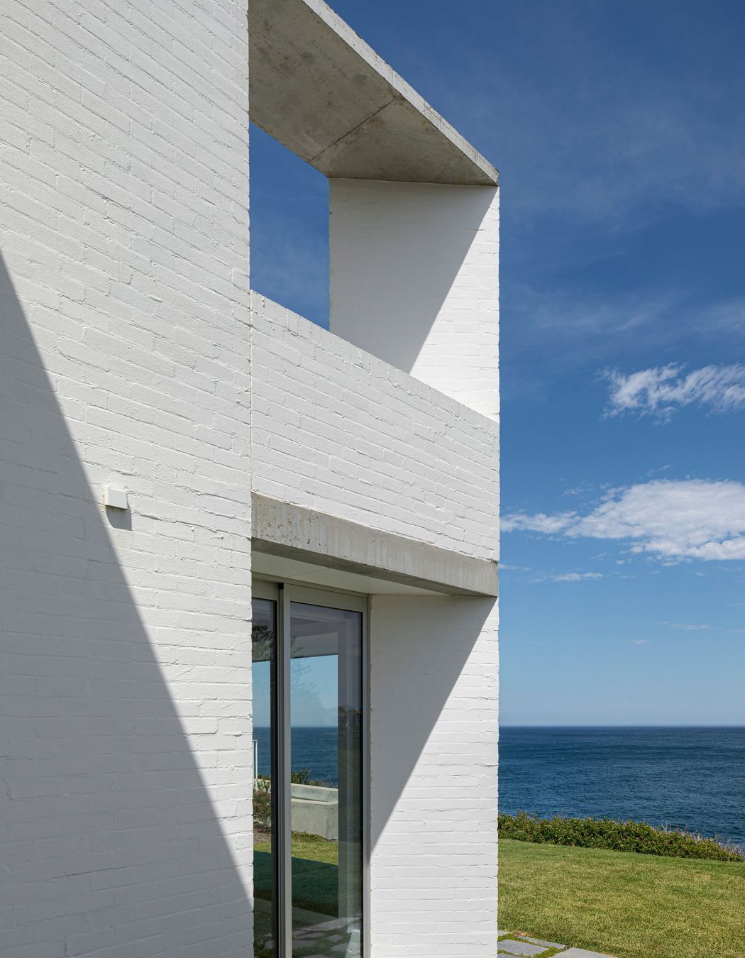 The bagged brick walls on either side of the house create two protective spines for the home.